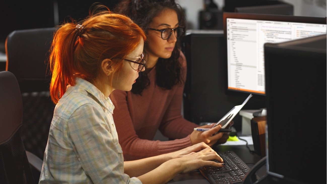 A photo of the Single Consent API team working together at a computer.